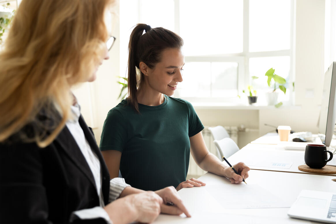 A woman counsellor with brown hair and green top receiving advice from a female counselling supervisor. 